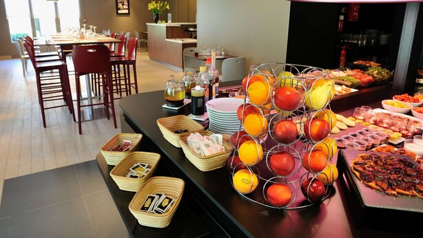 Een buffet met diverse gerechten, waaronder fruit en pizza.