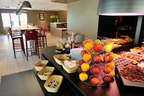 A buffet with various food items, including fruits and a pizza. - Campanile Bourg en Bresse - Viriat (Viriat)