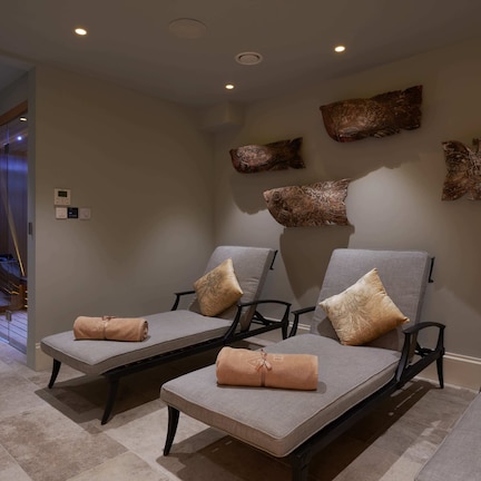 A spa area with reclining chairs, towels, and decorative fish wall art.