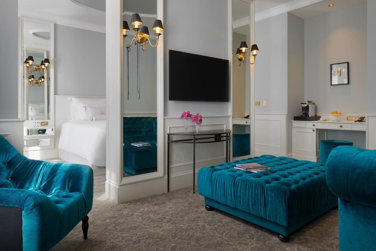 Deluxe suite, uitzicht op zee | Woonruimte | Een 49-inch lcd-televisie met digitale zenders en een televisie