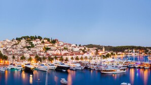 A coastal town with a marina filled with boats, historic buildings, and a prominent church. - Adriana Hvar Spa Hotel (Hvar)