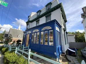 A two-story house with a blue bay window and a white steeple. - Fort Place Bed & Breakfast (Staten Island)