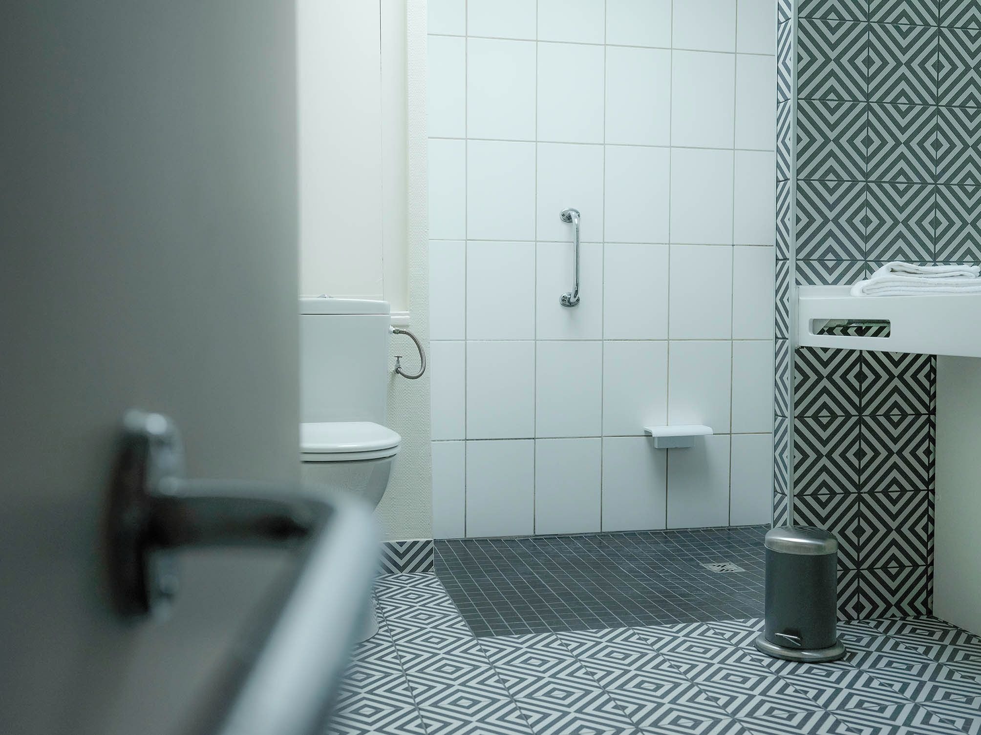 A bathroom with a toilet, a shower, and a sink.