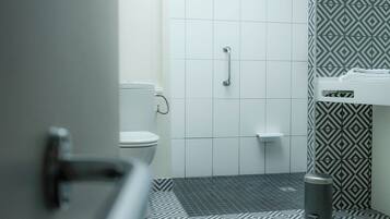 A bathroom with a toilet, a shower, and a sink.