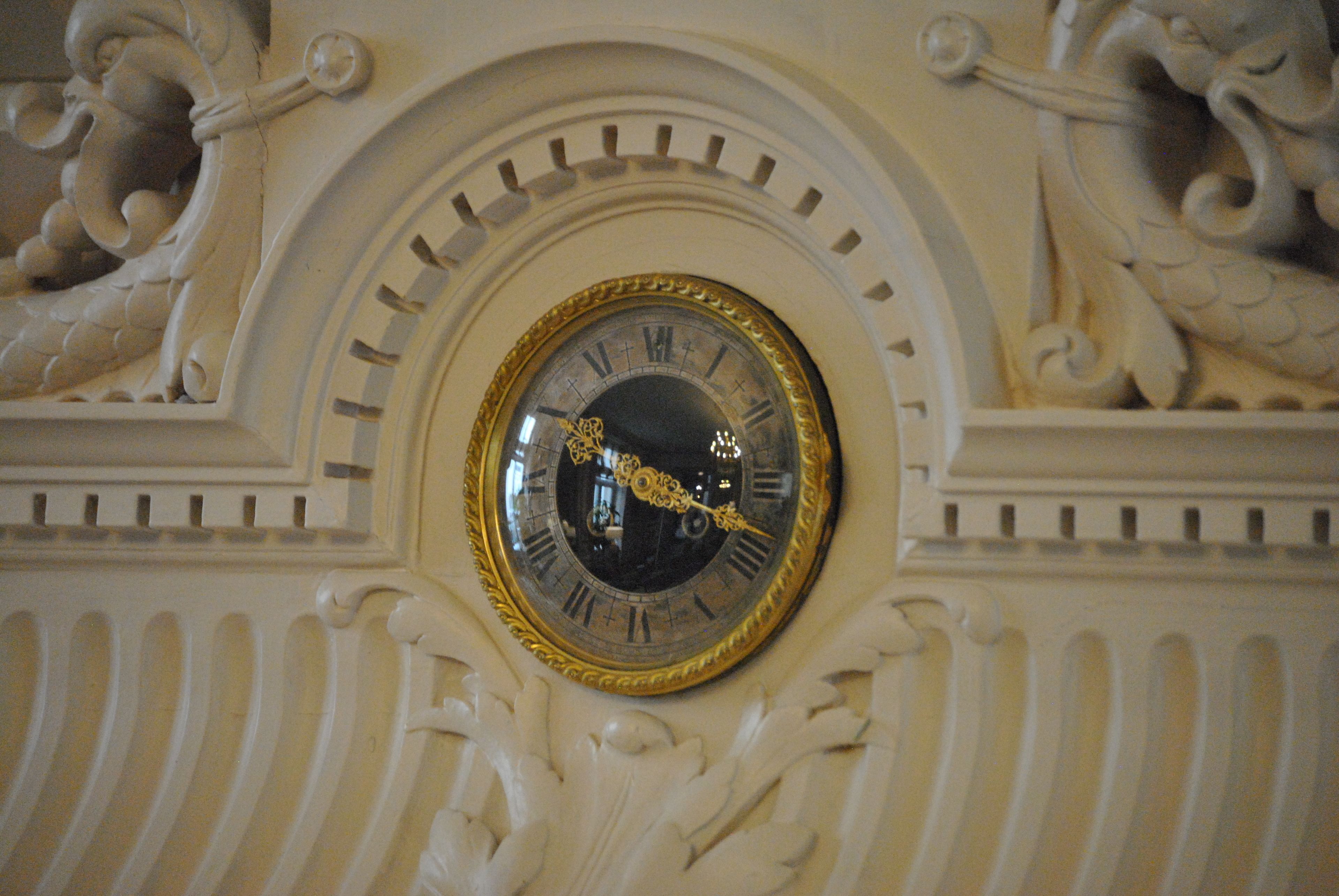 A detailed clock with Roman numerals and ornate carvings.