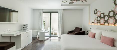 Una habitación de hotel moderna con una cama grande, un escritorio y un televisor.