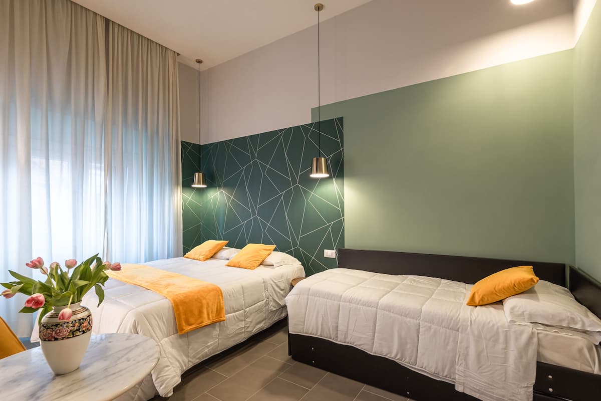Ein Hotelzimmer mit zwei Betten, einem Blumenstrauß und einem Tisch.