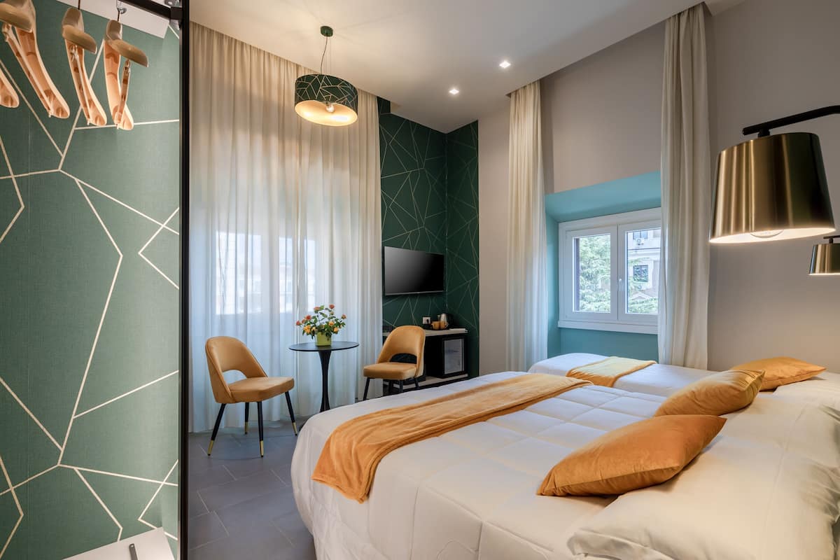 Ein modernes Hotelzimmer mit einem großen Bett, einem Schreibtisch, einem Stuhl, einem Fernseher und einem Vorhangfenster.