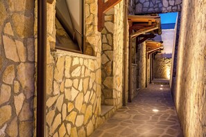 A stone pathway leading to a building with a stone facade and wooden beams. - The Strand Hotel (Rome)