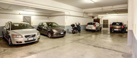 A multi-level parking garage with several cars and a motorcycle parked.