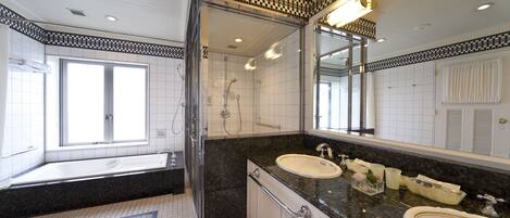 Un baño moderno con un espejo grande, dos lavamanos, una bañera y zona de ducha.