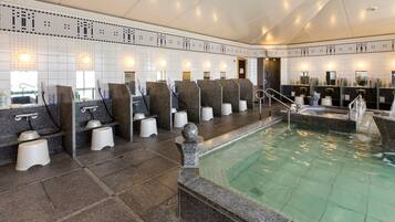 A modern spa with multiple seating areas, a central pool, and a tiled wall with a decorative pattern.