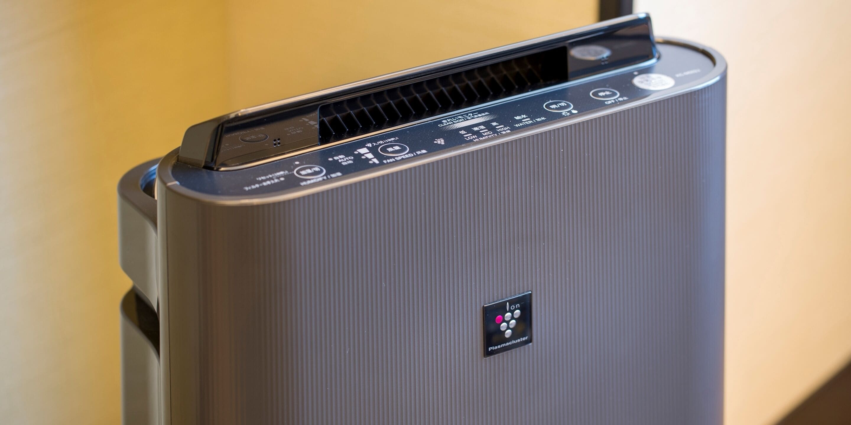 A modern, compact air purifier with a control panel featuring multiple buttons and a digital display.