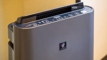 A modern, compact air purifier with a control panel featuring multiple buttons and a digital display.