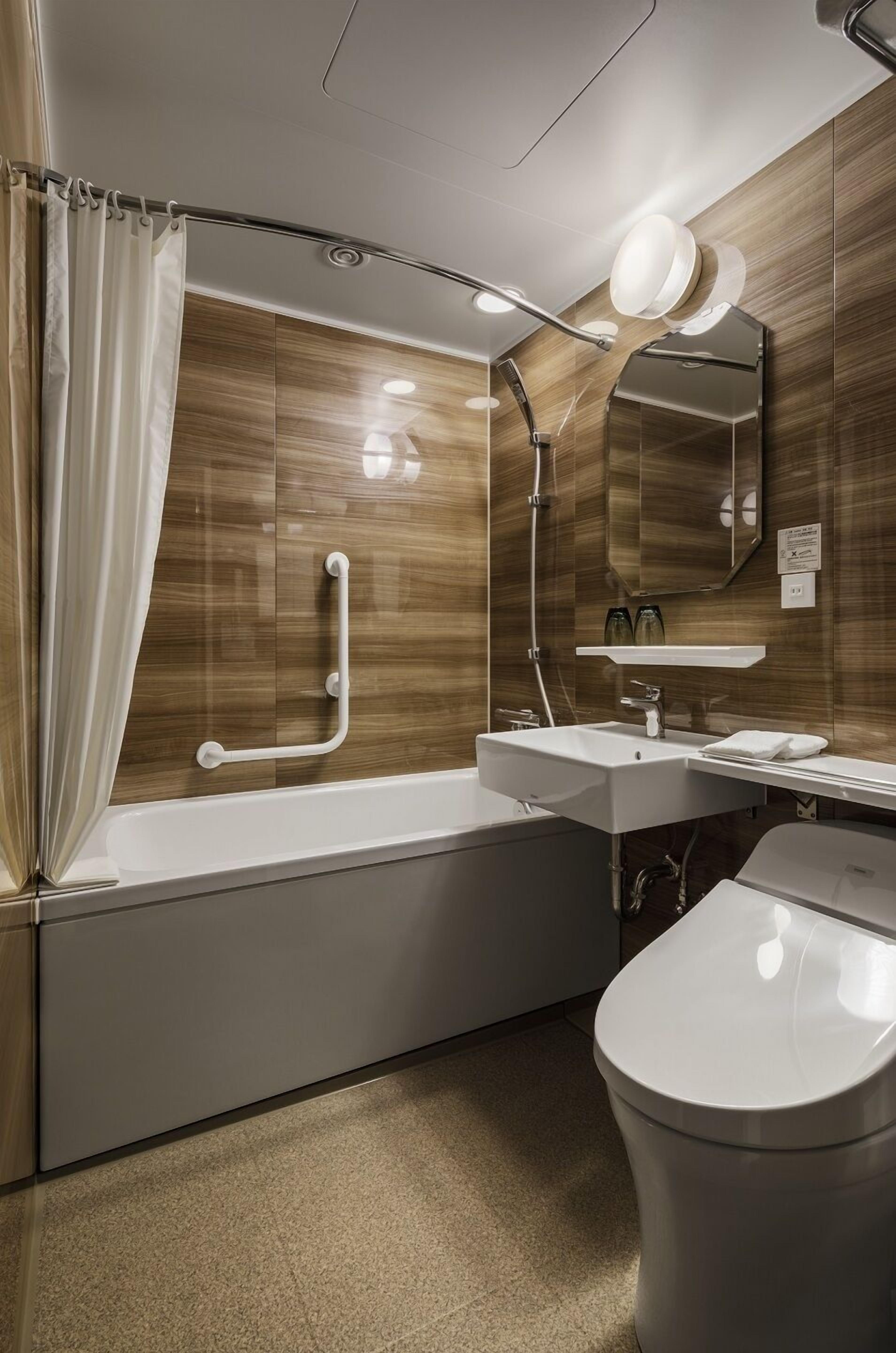 Ein modernes Badezimmer mit Badewanne, Waschbecken, Toilette und Dusche.