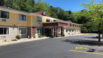 Un motel à plusieurs étages, arborant l’enseigne « Days Inn & Suites », doté d’une entrée couverte et d’un parking comprenant des places réservées aux personnes handicapées.