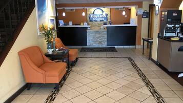 A reception area with a reception desk, a coffee machine, and seating with a view of the reception.