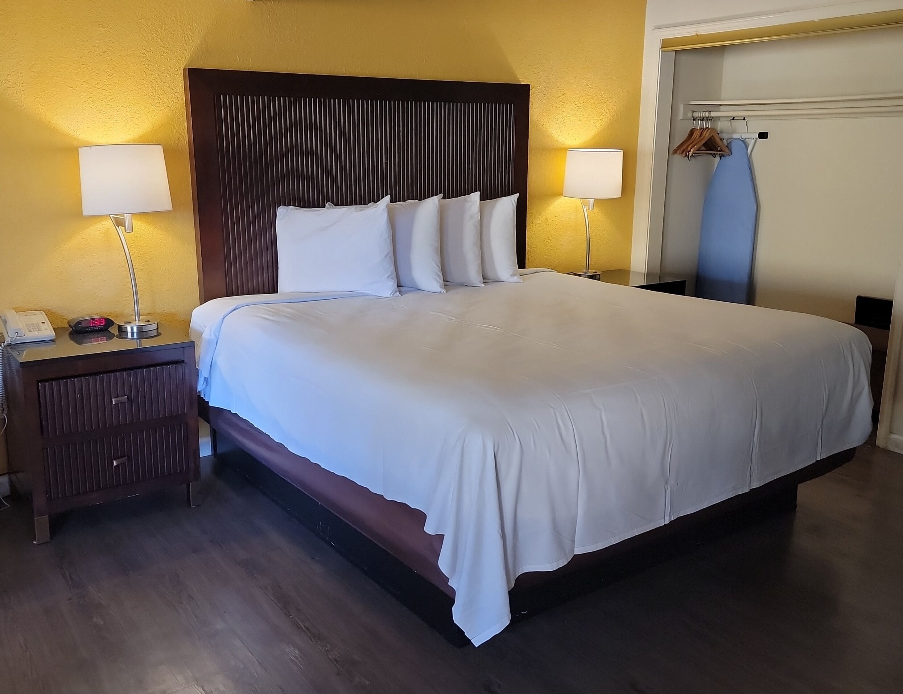 Una cama bien hecha con sábanas blancas en una habitación de hotel.
