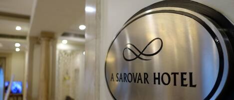 Letrero de A Sarovar Hotel con un símbolo de infinito estilizado sobre el texto.