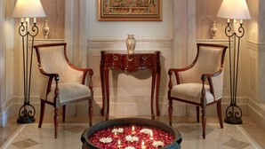A lobby with two armchairs, a small table with a vase, and a decorative mirror on the wall. - Park Plaza Jodhpur (Jodhpur)