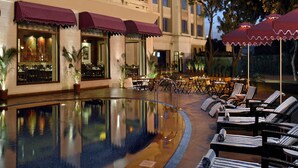 A hotel with a swimming pool, outdoor seating, and a restaurant with a view of the pool. - Park Plaza Jodhpur (Jodhpur)