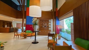 A spacious lobby with modern furniture, a reception desk, and large windows offering a view of the outdoors. - The Seasons Pattaya (Pattaya)