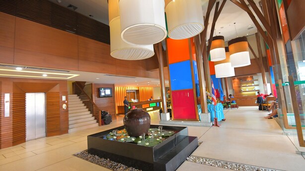 A modern lobby with a central water feature, a reception desk, and a staircase. - The Seasons Pattaya (Pattaya)