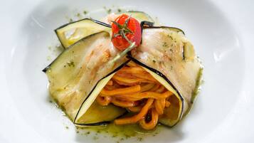 A plate of food with sliced vegetables and a cherry tomato garnish.