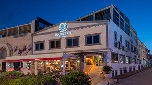 A DoubleTree by Hilton hotel with a modern facade, a covered outdoor seating area, and a staircase leading to the entrance. - DoubleTree by Hilton Bodrum Marina Vista (Bodrum)