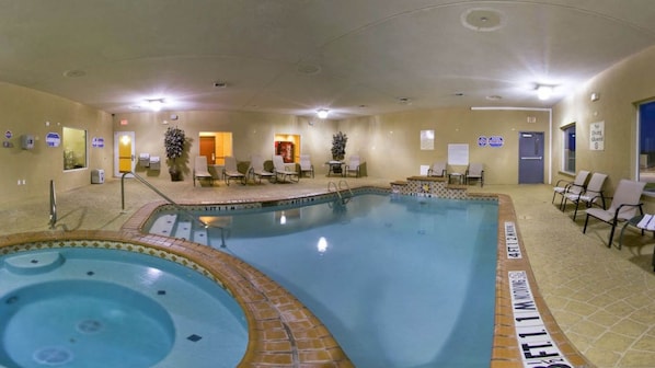 Uma área de piscina com hidromassagem, espreguiçadeiras e um espaço para sentar.