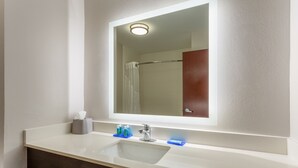 A bathroom with a white sink, a mirror, and a shower curtain. - Holiday Inn Express Hotel & Suites Charlotte Arrowood by IHG (Charlotte)