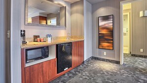 A modern hotel bathroom with a large mirror, a built-in microwave, and a sink. - Courtyard by Marriott Harrisburg West/Mechanicsburg (Mechanicsburg)