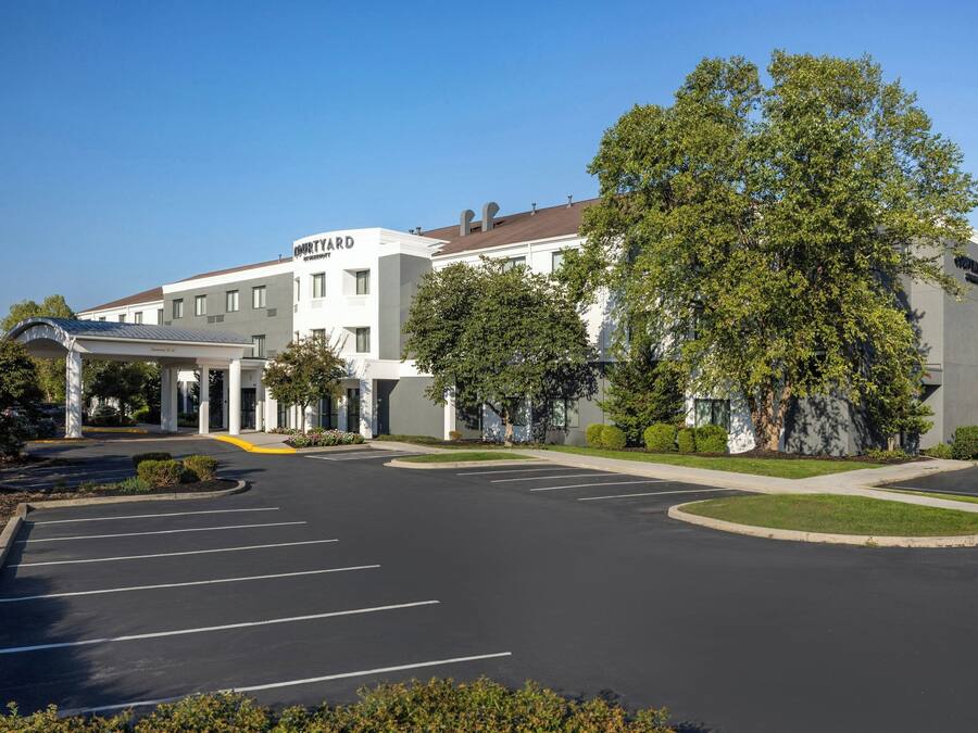 A modern building with a sign reading "MOTYARD" and a parking lot with marked spaces.
