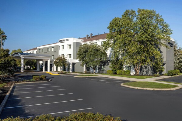 A modern building with a sign reading "MOTYARD" and a parking lot with marked spaces.