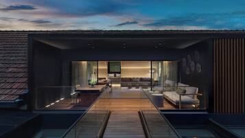 A modern interior with a wooden floor, glass walls, a sofa, and a TV.