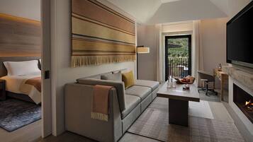 Un salon moderne avec un canapé, une table basse, une cheminée et un téléviseur.