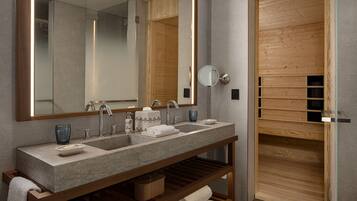Un baño moderno con un espejo grande, dos lavamanos y estantes de madera.