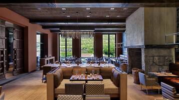 Un restaurant doté d’une longue table à manger, de sièges confortables et d’une cheminée en pierre.