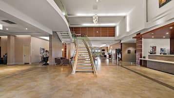 Stunning lobby with a grand staircase, reception desk, and comfortable seating areas.