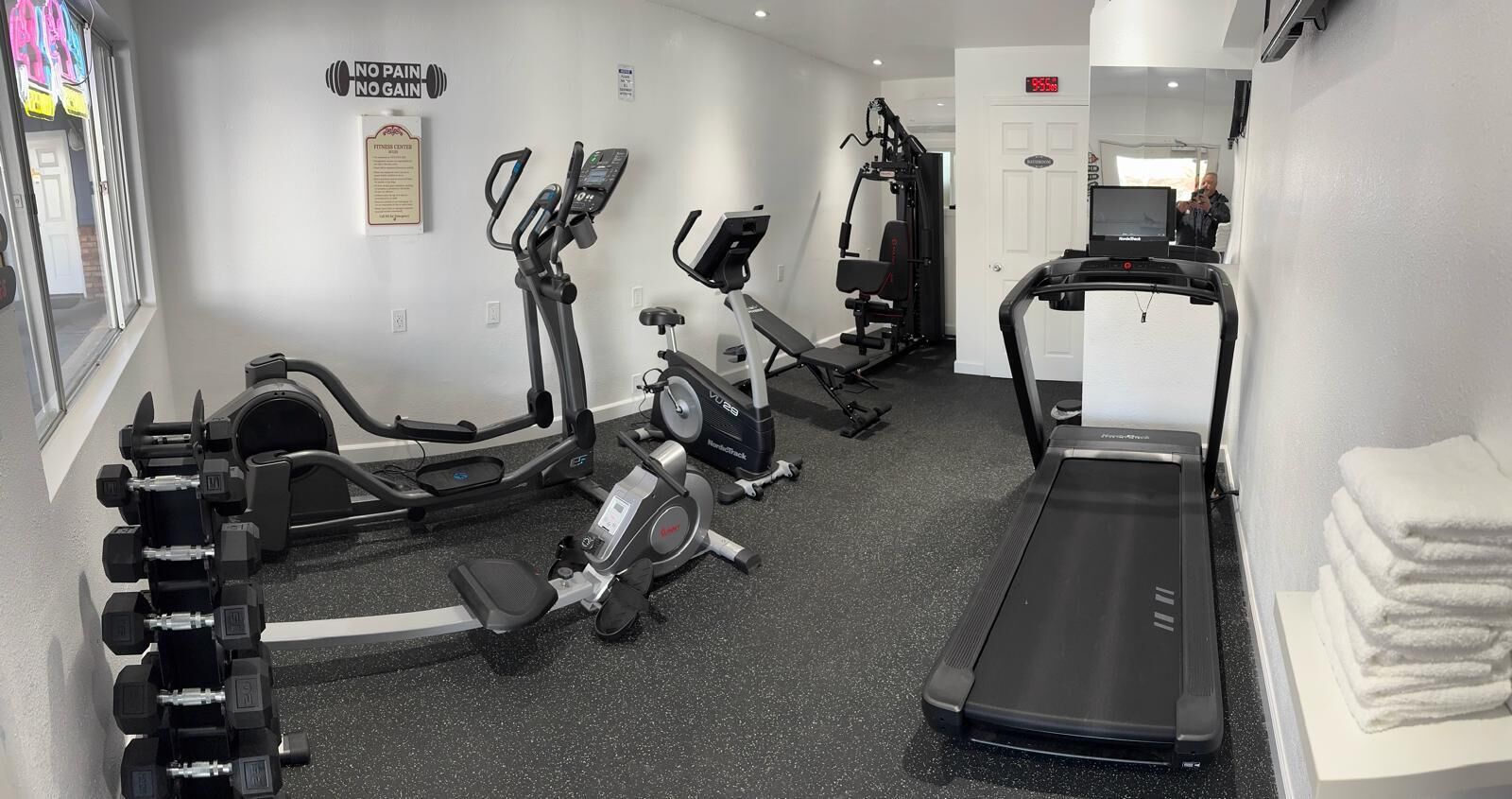 A gym with cardio machines, weight machines, and a treadmill.
