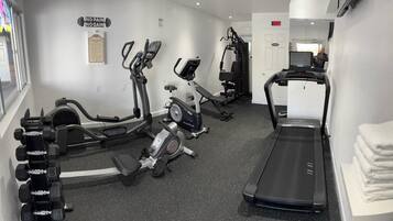 A gym with cardio machines, weight machines, and a treadmill.