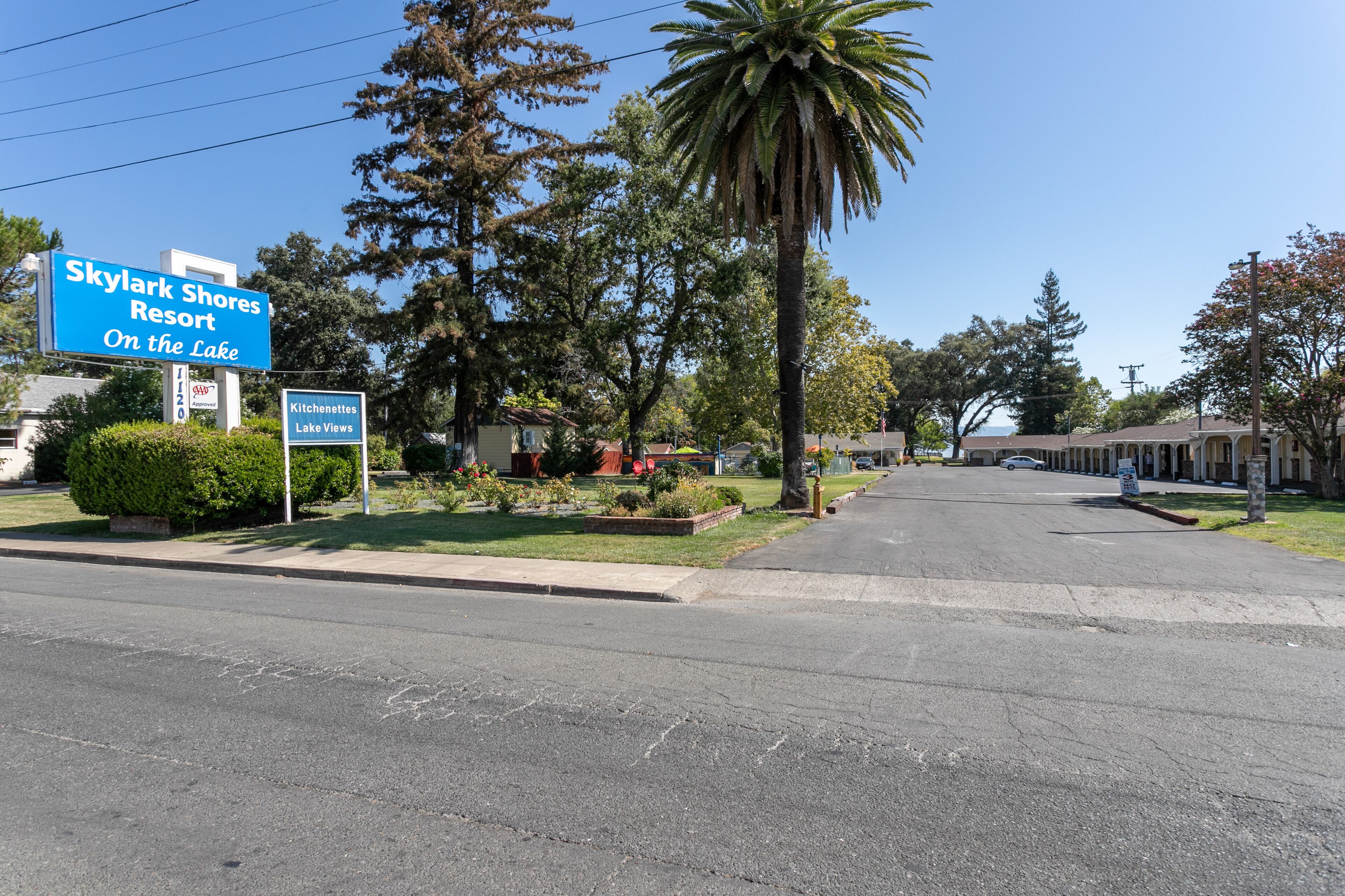 Une vue de la rue donnant sur le complexe Skylark Shores Resort, avec une enseigne indiquant « Kitchentines, vue sur le lac ».
