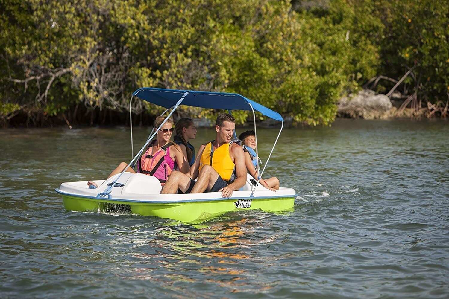 A green and white boat with a blue canopy, labeled 'Pelican', on calm water.
