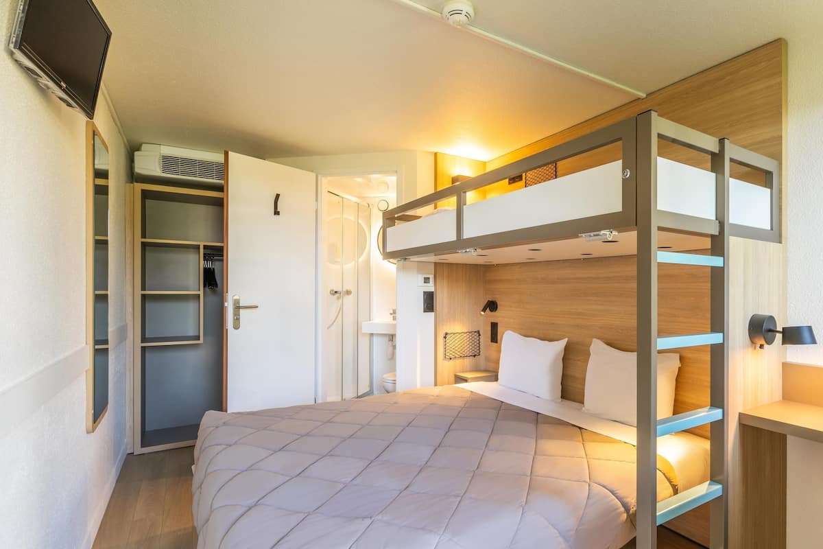 Ein Schlafzimmer mit Etagenbett, Schreibtisch und Kleiderschrank.