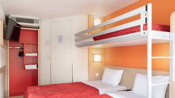 Habitación con literas, una colcha roja, un armario y un televisor montado en la pared.