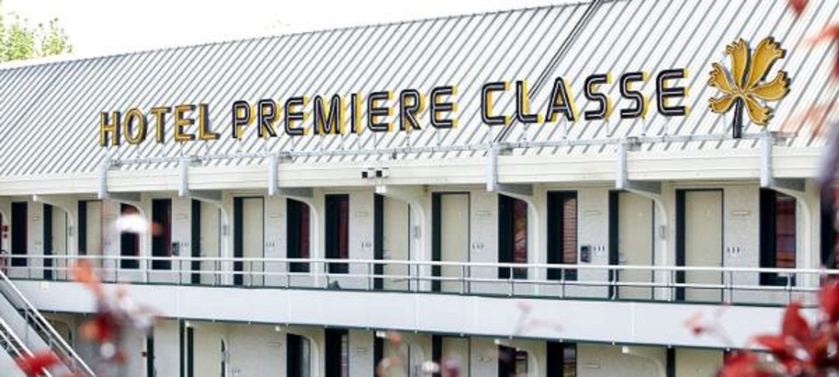 Een hotel genaamd "HOTEL PREMIERE CLASSE" met een rij kamers en een balkon.