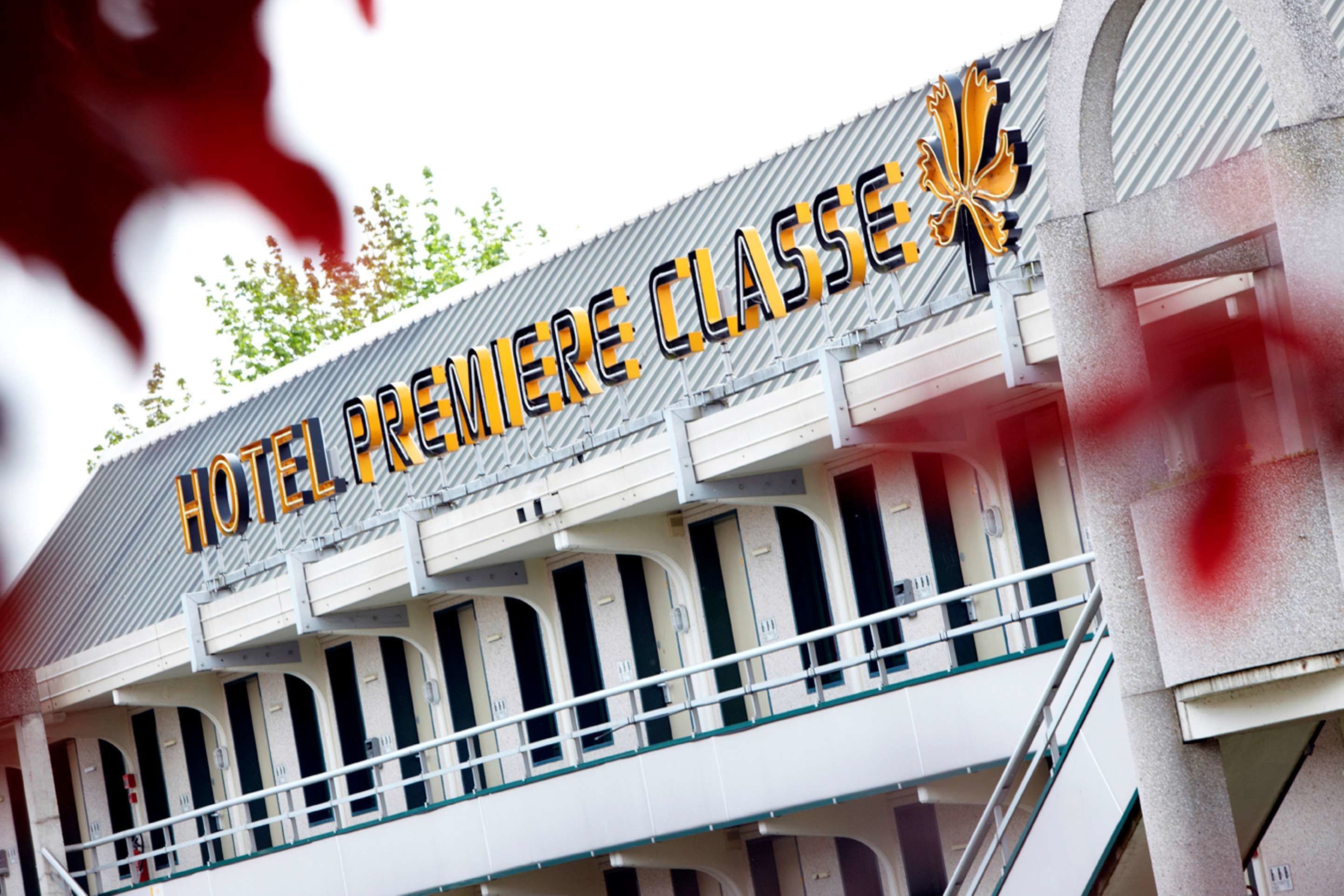 Un letrero de hotel con el texto "HOTEL PREMIERE CLASSE" y un logotipo.