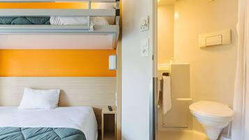 A hotel room with a bunk bed, a small bedside table, a white toilet, and a shower area.