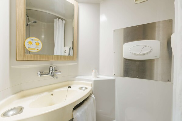 A bathroom with a sink, mirror, and shower.