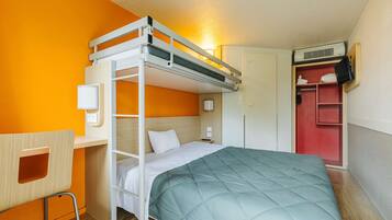 A bunk bed with a desk and chair, a wardrobe, and a wall-mounted air conditioner.